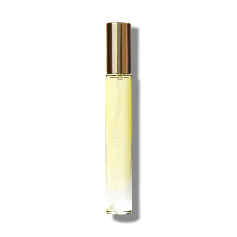 A cylindrical bottle of Caswell Massey Peony Perfume - 7ml with a golden cap, placed against a stark white background, casting a soft shadow to the right.