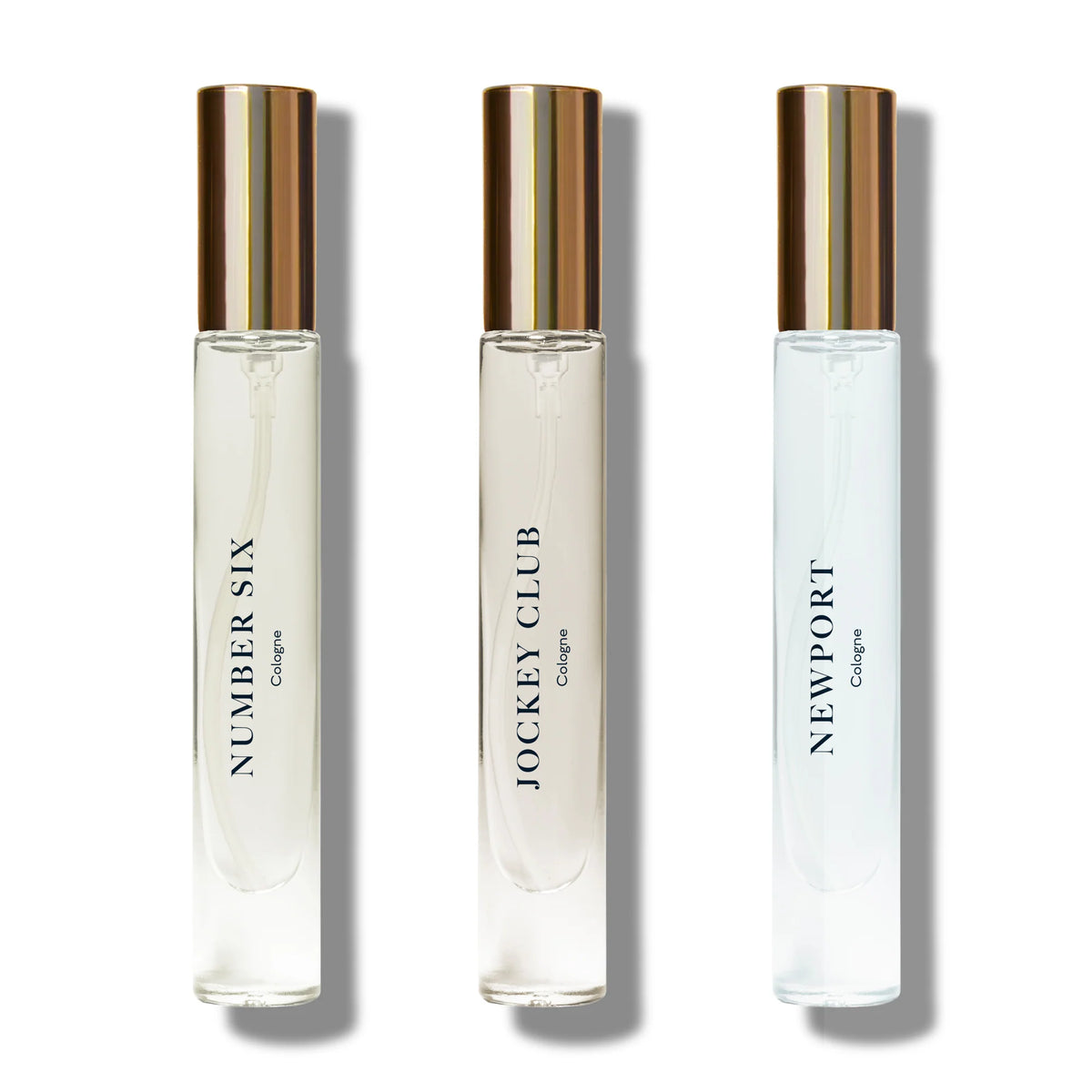 Three elegant Caswell Massey Cologne Discovery Set bottles in a line on a white background, labeled "number six," "jockey club," and "newport" respectively, each with a gold cap