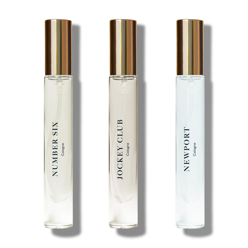 Three elegant Caswell Massey Cologne Discovery Set bottles in a line on a white background, labeled "number six," "jockey club," and "newport" respectively, each with a gold cap
