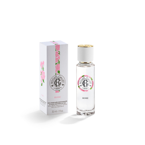 A bottle of Roger & Gallet Rose - Wellbeing fragrant water next to its box, both adorned with pink floral designs on a white background.
