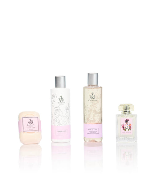 Four elegant Carthusia Christmas Villa Jovis – Fiori di Capri Gift Box beauty products in a row, including a soap bar, two lotion bottles, and an eau de parfum bottle, all with decorative, floral designs on white background.