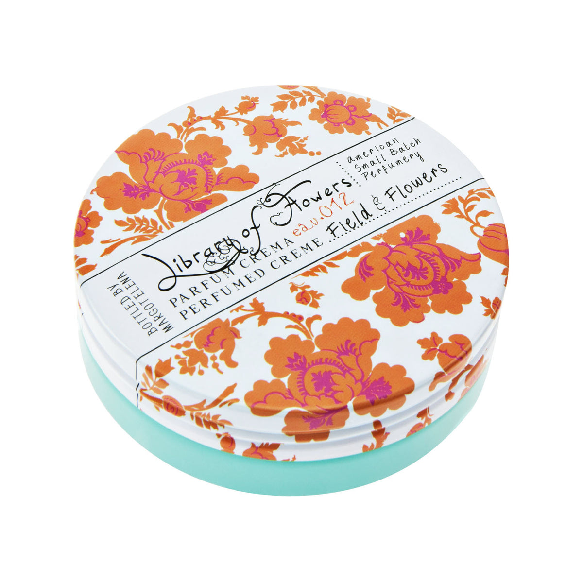 A round tin of Margot Elena Library of Flowers Field & Flowers Parfum Crema with an orange floral design on the lid and teal base. The label displays the scent as "Field & Flowers.