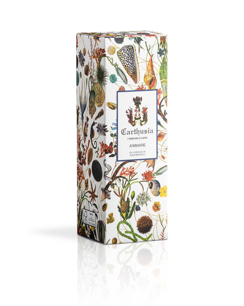 A beautifully designed Carthusia I Profumi de Capri A'mmare Shower Oil box with intricate illustrations of various botanical elements, including flowers, leaves, and fruits enriched with jojoba oil, on a white background.