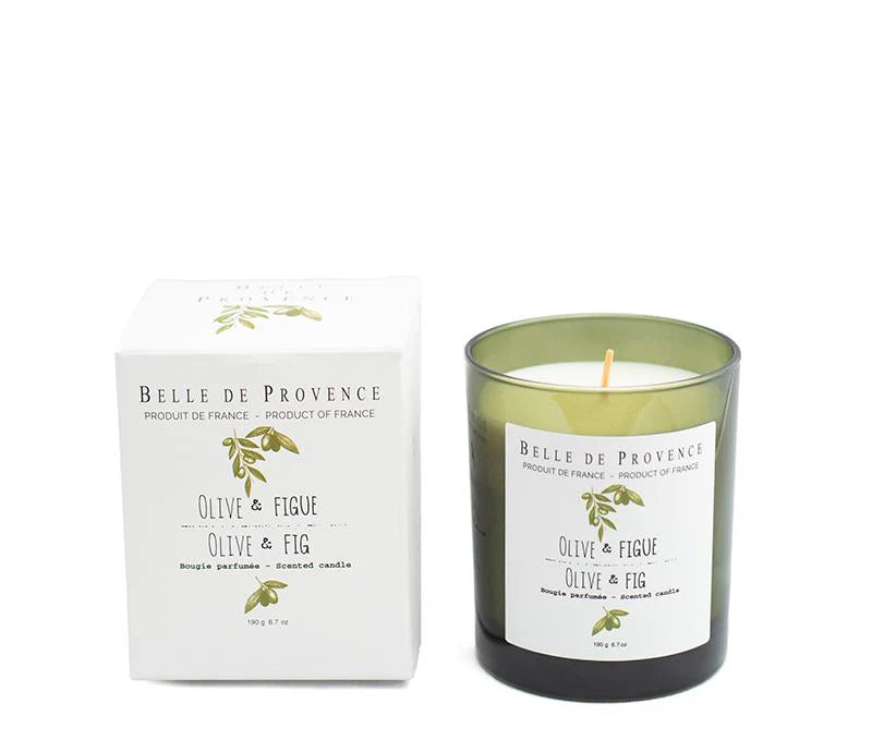A Lothantique Belle de Provence Olive & Fig 190g Scented Candle is shown next to its box. The candle, crafted from vegetable wax, is housed in a green glass container with a white label that reads "Olive & Fig." The sleek white box features similar text and an illustration of olive branches, evoking herbal fragrances.