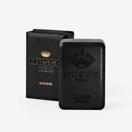 Two black Claus Porto Musgo Real Black Edition Body Soap products, one bar and one box, both featuring ornate white logos, against a neutral background.