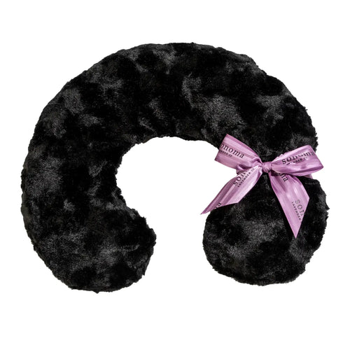 A black, plush neck pillow shaped like a horseshoe, accented with a light pink satin ribbon tied in a bow on the right side and infused with lavender for aromatherapy benefits - Sonoma Lavender Onyx Mink Neck Pillow by Sonoma Lavender.