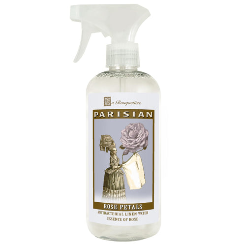A transparent spray bottle labeled "La Bouquetiere Rose Petal Antibacterial Linen Water" with an elegant design featuring an illustration of a vintage woman and a large rose.