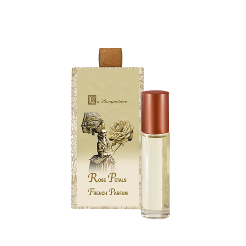 A bottle of La Bouquetiere Rose Petal Perfume Roller with its elegant packaging, featuring a vintage-style illustration of a woman and a rose.