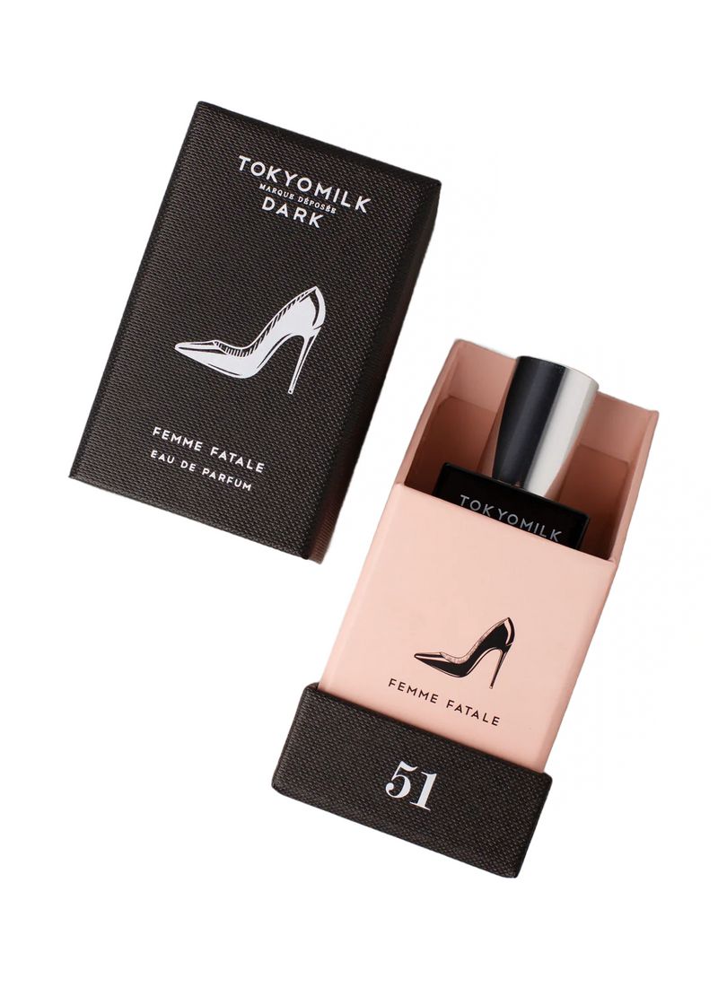 A bottle of Margot Elena's TokyoMilk Dark Femme Fatale No. 51 Eau De Parfum partially encased in its black and pink packaging, featuring a high-heeled shoe design.