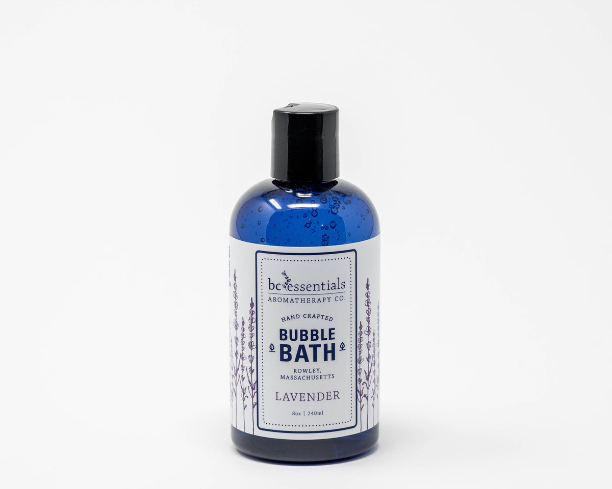 A blue bottle of BC Essentials baby-safe lavender bubble bath with water droplets on its surface, isolated against a white background.