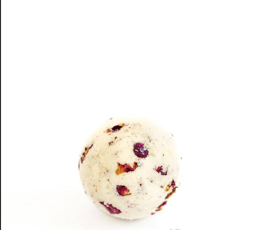 A single SOAK Bath Co. Rose Petal Bath Bomb with dried rose petals embedded, isolated on a white background.