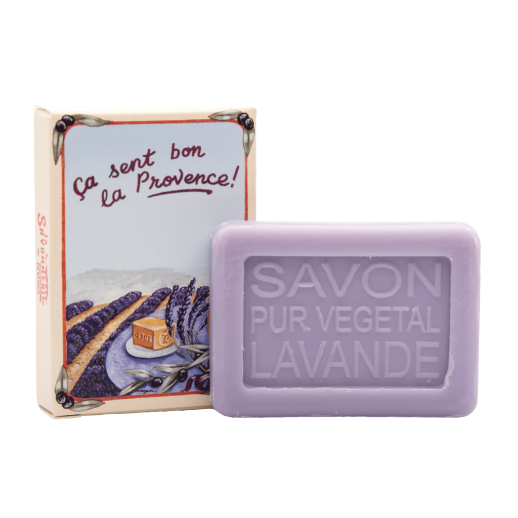 A bar of lavender soap labeled "La Savonnerie de Nyons Provence Lavande" next to its packaging with an illustration showing a Lavender Wild field and text "ça sent bon la provence!
