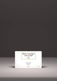 A vintage-style Jean d'Aigle Carnation Soap label displayed on a plain white card, placed on a flat surface against a soft gray backdrop, highlighting elegant black and red typography.