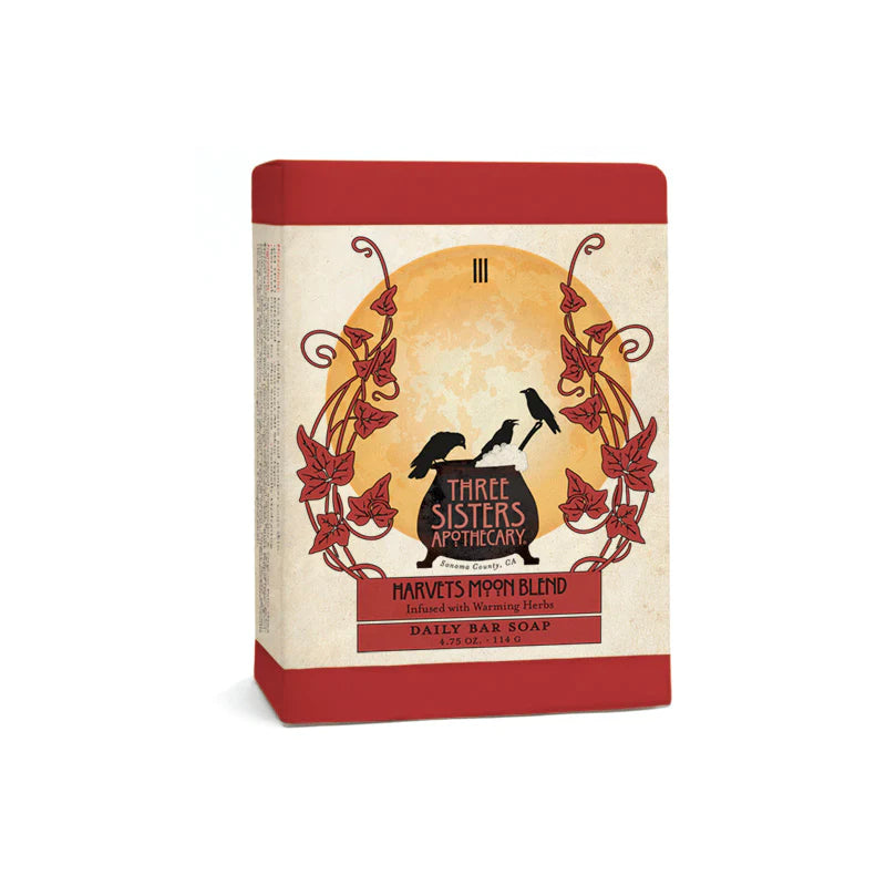 A rectangular red and beige soap packaging for Three Sisters Apothecary Harvest Moon bar soap featuring silhouettes of birds and leaves with an elegant vintage design.