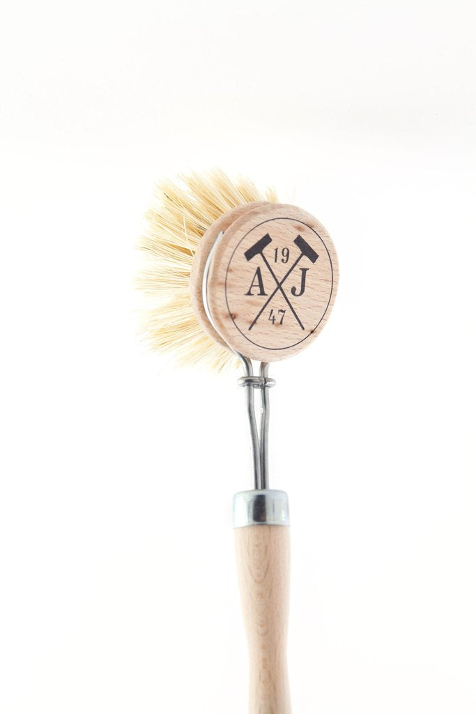 A Andrée Jardin Tradition Handled Dish Brush with a round head, marked with the engraved logo "aj 19 47" and made in France, positioned against a white background.
