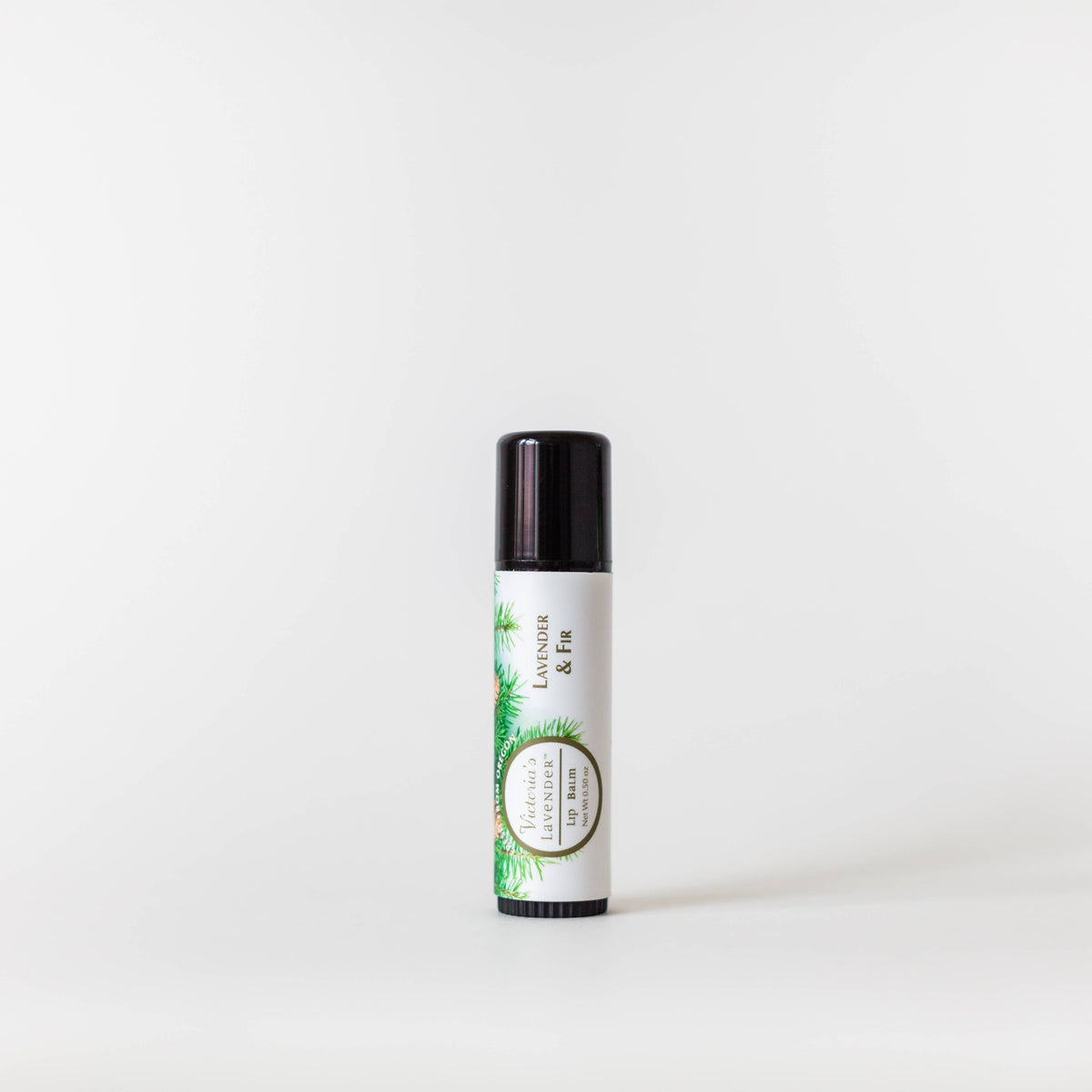 A cylindrical container of Victoria's Lavender - Lavender Fir Healing Lip Balm with a white label featuring green botanical illustrations, displayed against a plain white background.
