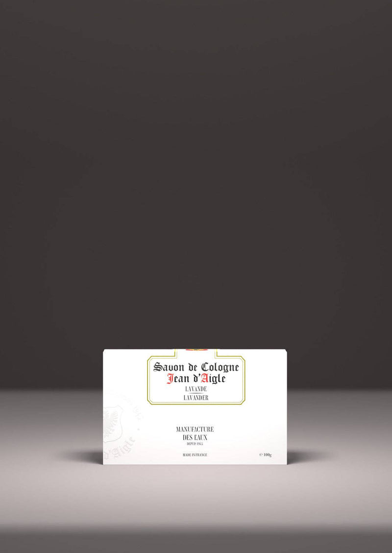 A bar of soap with the label "Jean d'Aigle Lavender Soap" displayed on a minimalistic gray background. The text is centered on the wrapper in an elegant, classic font.
