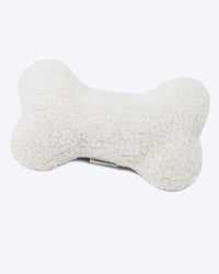 A fluffy white bone-shaped pillow designed for dogs, featuring a soft, textured fabric. The pillow has a visible label on the front with the brand name "MODERNBEAST Zenbone.