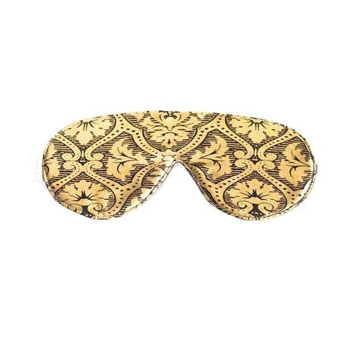 A decorative Elizabeth W silk sleep mask with an intricate gold and black pattern on a white background.