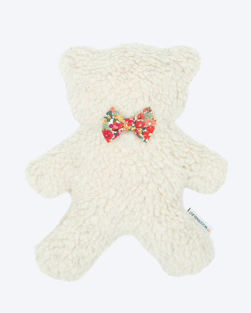 A plush, white MODERNBEAST Lavender Bedtime Bear with a colorful floral bow tie, isolated on a white background. A small red tag is visible on its side, marking it as a calming lavender bedtime bear.