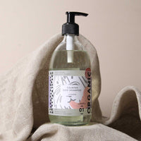 A bottle of Made & Sent Calming Dog Shampoo 500ml with lavender scent, displayed on a beige cloth against a neutral background. The label features modern fonts and designs.