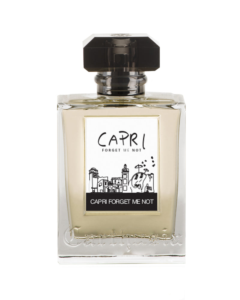 A clear square perfume bottle labeled "Carthusia Capri Forget Me Not Eau de Parfum" by Carthusia I Profumi de Capri with a sketch of a scenic view, and a black cap, against a white background.