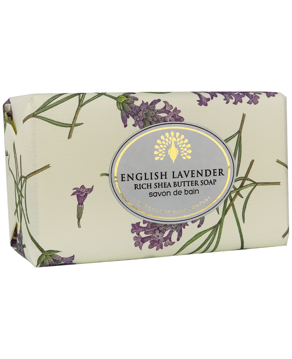 A bar of The English Soap Co. English Lavender Vintage Italian Wrapped Soap wrapped in paper featuring lavender illustrations and text stating "rich vegan friendly soap" in both English and French.