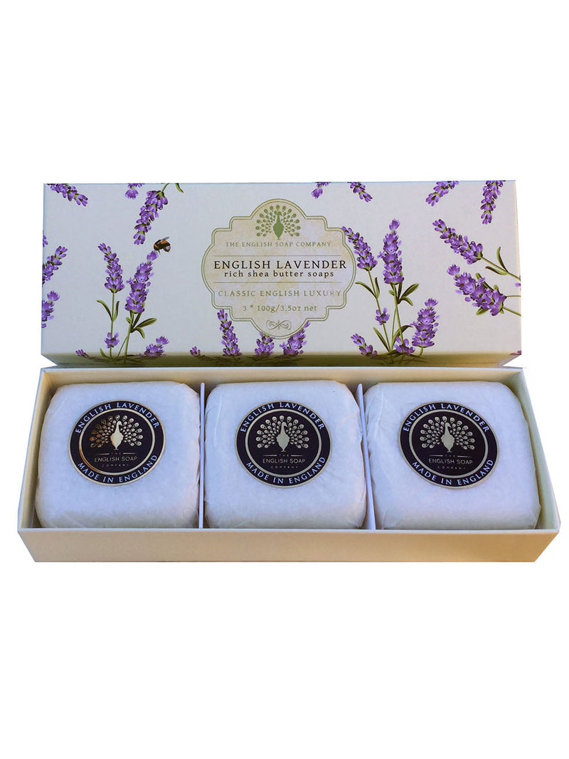 An elegant gift box containing three bars of The English Soap Co. English Lavender hand soaps, each bar individually wrapped in white paper, set against a floral background on the box lid.