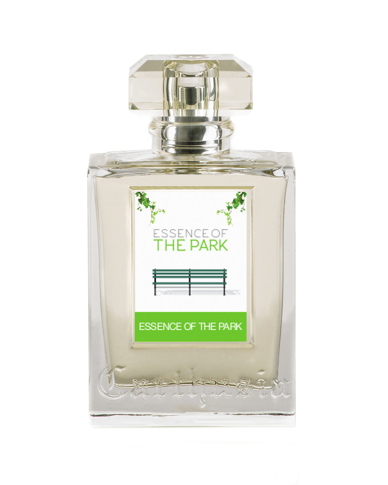 A transparent perfume bottle labeled "Carthusia Essence of the Park" with an image of a park bench and green leaves depicted inside. The cap is faceted and clear, exuding a classic fragrance.