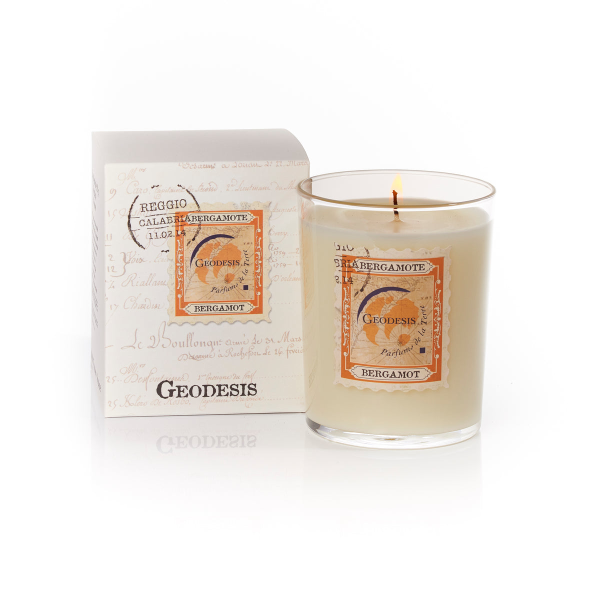 A Geodesis Bergamot 220gm scented candle in a clear glass jar beside its packaging, which features elegant script and vintage-style labels.