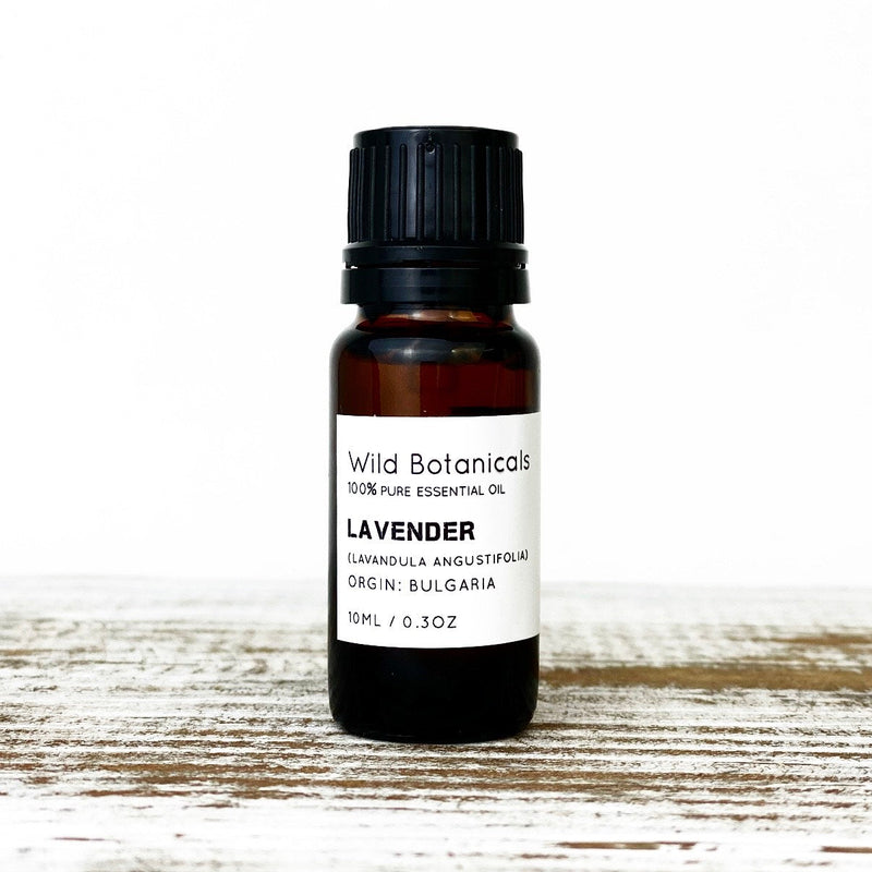 A bottle of Wild Botanicals Lavender (Bulgarian) essential oil on a wooden surface, clearly labeled with details including origin and size, known to promote sleep.