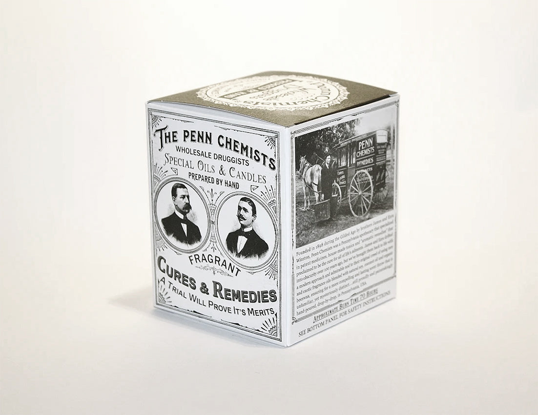 A vintage-style Penn Chemists Classic Candle - Lady Day box featuring monochrome images of a man, a horse-drawn carriage, and text advertising drugs, hand-poured candles, and cures.