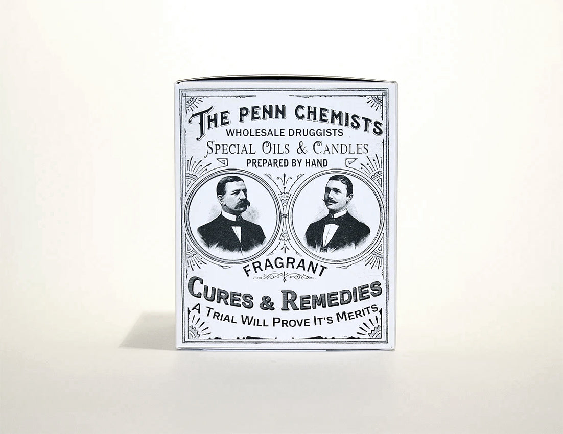 Vintage advertisement for "Penn Chemists" featuring portraits of two men, promoting Penn Chemists Classic Candle - Cut & Shave with text emphasizing hand-prepared products and cures. Now enhanced with the cologne scent.
