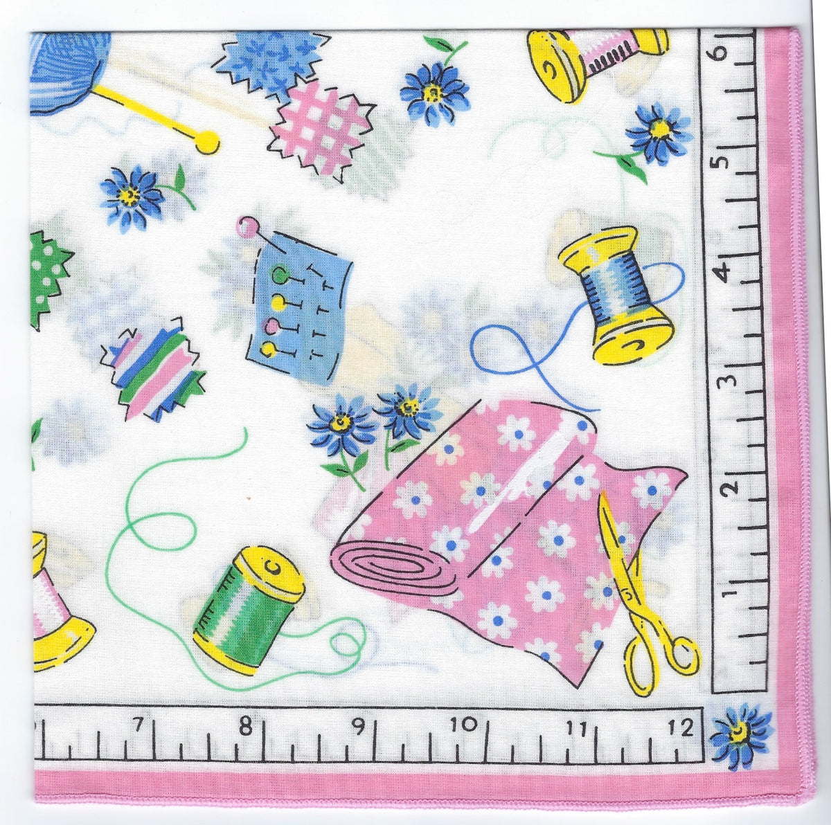 A colorful fabric pattern featuring sewing and crafting motifs such as thread spools, scissors, yarn balls, Vintage Inspired Hankies - Sewing Notions & Needlework, displayed next to a measuring tape showing inches from Hankies ala Carte.