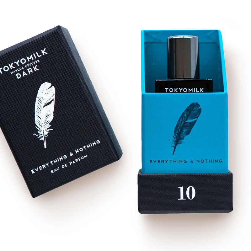 Two TokyoMilk Dark Everything & Nothing No. 10 Eau de Parfum boxes from Margot Elena, one black with a white feather design, labeled "everything & nothing" and number 10. The other shows part of the perfume bottle in a vibrant hue.