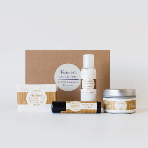 A variety of Victoria's Lavender - Vanilla Lavender Moisturizing Body Care Gift Set products are displayed against a white background, including handmade soap, lotion, healing lip balm, and other packaged items labeled in a cohesive design theme.