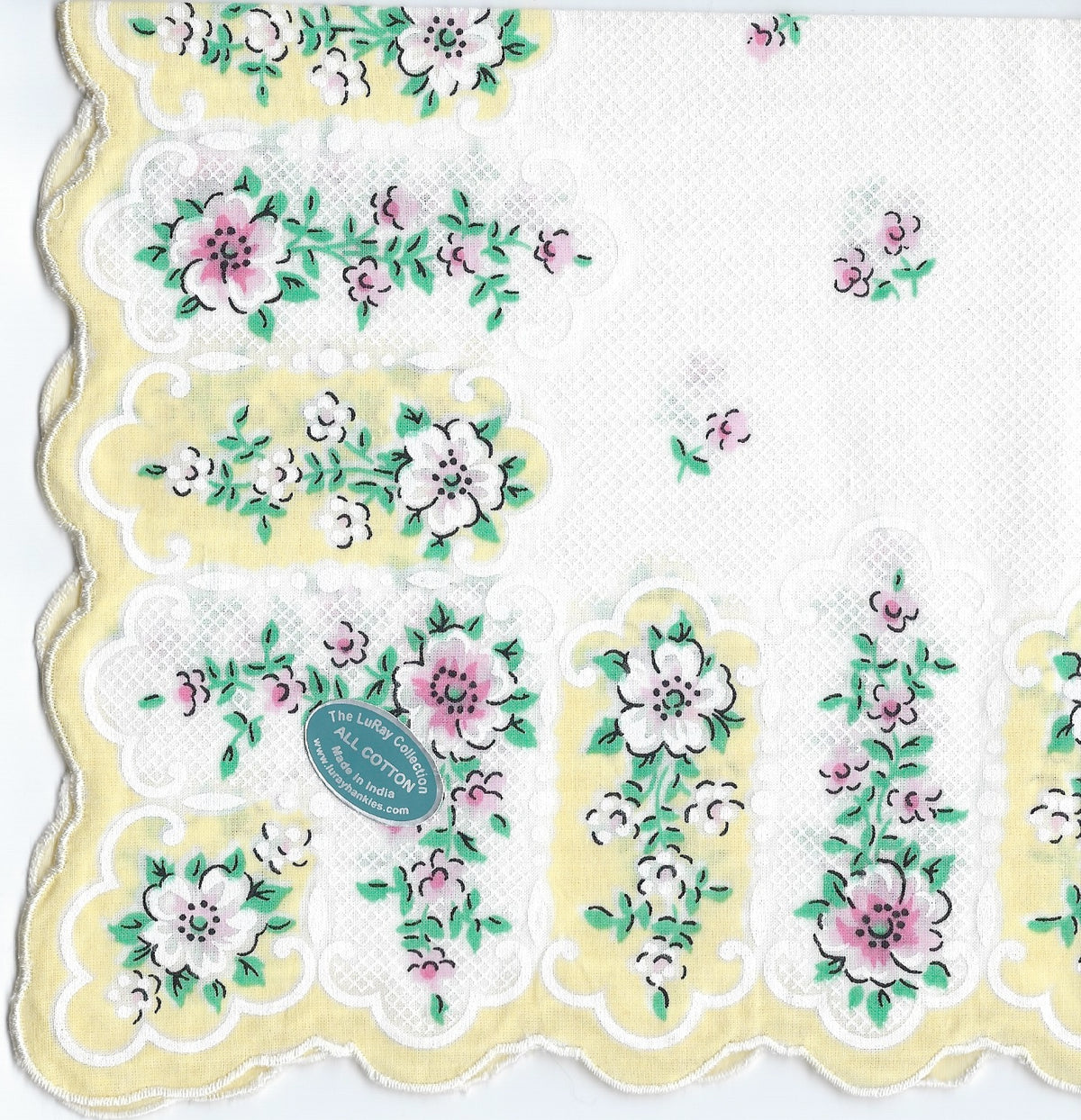 A detailed image of a Vintage-Inspired Hanky from Hankies ala Carte, with a scalloped edge, featuring intricate lace patterns and embroidered floral designs in shades of pink, green, and white.