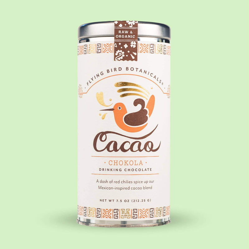 A can of Flying Bird Botanicals Chokola Cacao organic drinking chocolate, featuring an illustration of a flying bird and a cup, with text and decorative patterns around the can. The background is pastel green.