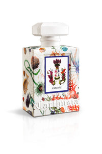A decorative Carthusia A'mmare fragrance bottle with a white cap and a colorful botanical and marine life illustration on its surface, featuring a central label with the text "ammare.