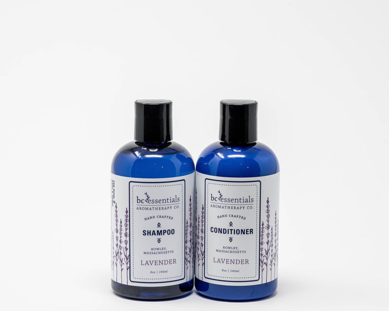 Two blue bottles labeled "BC Essentials aromatherapy co." one is BC Essentials Lavender Shampoo and the other conditioner, both lavender scented, against a white background.