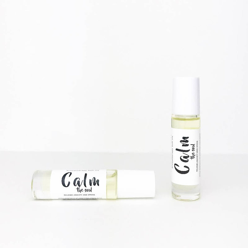 Two Wild Botanicals Calm Aromatherapy Roll-On bottles labeled "calm" with essential oils against a plain white background, one standing upright and the other lying horizontally.