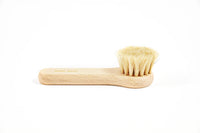 An Andrée Jardin Tradition Face Cleansing Brush Waxed Beech Wood with natural bristles lies on a plain white background, showcasing its simple and ergonomic design.