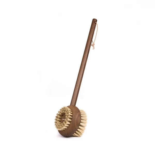 A wooden toilet brush with a long handle made of French-sourced ash wood and natural bristles, standing upright against a white background is the Andrée Jardin Heritage Ash Wood Handled Body Brush from Andrée Jardin.