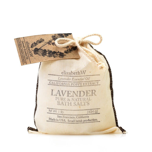 A small, beige fabric bag of "elizabeth W Purely Essential Lavender Bag of Salts" with a lace design and a rustic tag, tied with a natural string, isolated on a white background.