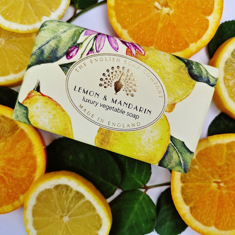 A bar of "The English Soap Co." Vintage Lemon Mandarin Italian Wrapped Soap, surrounded by fresh citrus slices, with the text emphasizing it is a luxury vegetable soap made in England.
