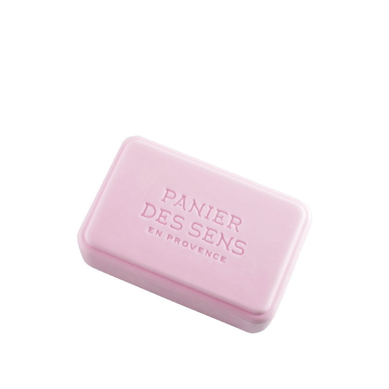A pink bar of Panier Des Sens Extra-Soft Vegetable Soap - Magnolia Peony with the embossed text "panier des sens en provence" on it, isolated on a white background.