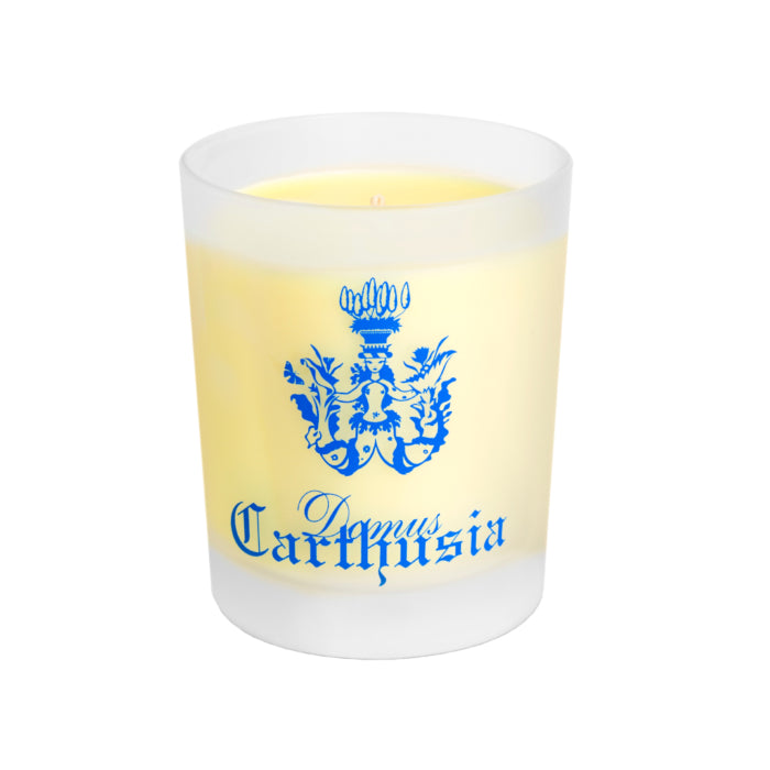 A white Carthusia Mediterraneo scented candle in a clear glass container with a yellow flame. The glass features a blue emblem and the word "Carthusia I Profumi de Capri" in decorative script.