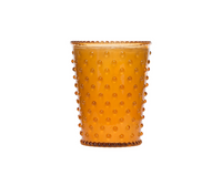 A textured amber glass tumbler with a dotted pattern all around, displayed against a plain white background, ideal for holding a Simpatico NO. 28 Pumpkin & Clove Hobnail Glass Candle.