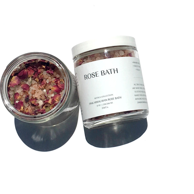 Two jars of Z&Co. Pink Himalayan Rose Bath salts labeled "rose bath", one opened to show pink Himalayan salt and dried rose petals inside, on a white background.