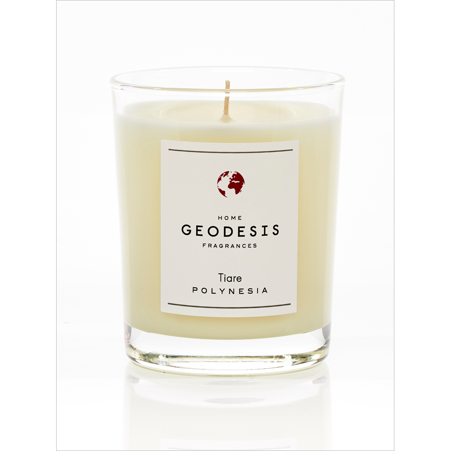 A Geodesis Tiare 180g Scented Candle with a label that reads "Tiare Polynesia" in a clear glass container, the wax inside is creamy white with a floral sweet scent.